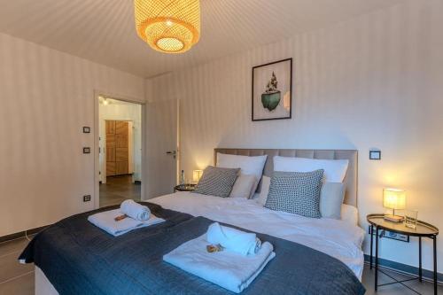 a bedroom with a large bed with two towels on it at Luxus am Park Altstadt-Barrierefrei-Parkplatz in Wetzlar