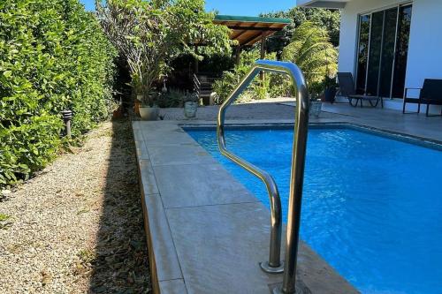 una piscina con una barra de metal al lado de una casa en Casa Abundia - Caracoles Studio, en Carrillo