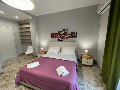 a bedroom with a large bed with a purple blanket at ROOM 110 BARI -guesthouse- in Bari