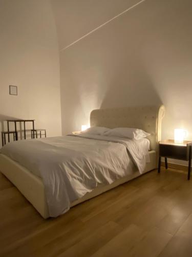 a bedroom with a white bed and a table at Le Stanze Di Ambra in Trani
