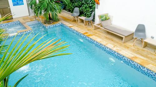 uma piscina com duas cadeiras e uma mesa e uma piscina em HOTEL LE FALEP em Anapoima