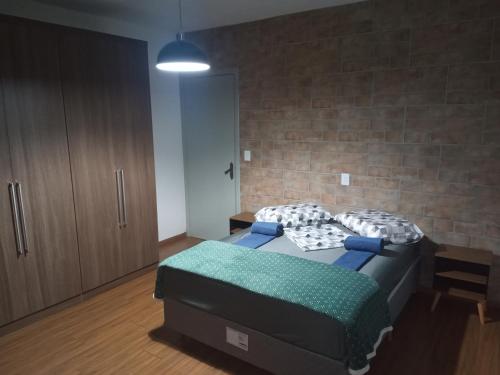 a bedroom with a bed and a brick wall at Casa em Bento Gonçalves próximo a Fundaparque. in Bento Gonçalves