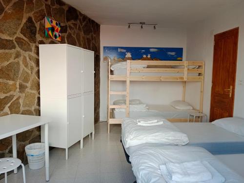 sypialnia z 3 łóżkami piętrowymi i biurkiem w obiekcie La Palma Hostel by Pension Central w mieście Fuencaliente de la Palma