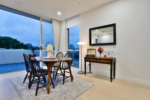 a dining room with a table and a desk with a mirror at Lumière Sanctuary - Antique Elegance with Parking in Sydney