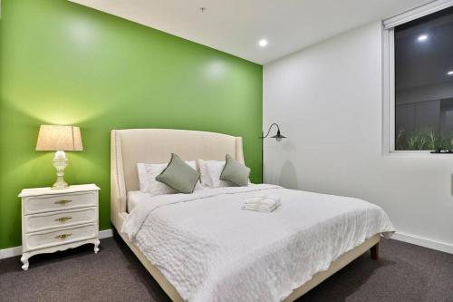 a green bedroom with a bed and a window at Lumière Sanctuary - Antique Elegance with Parking in Sydney