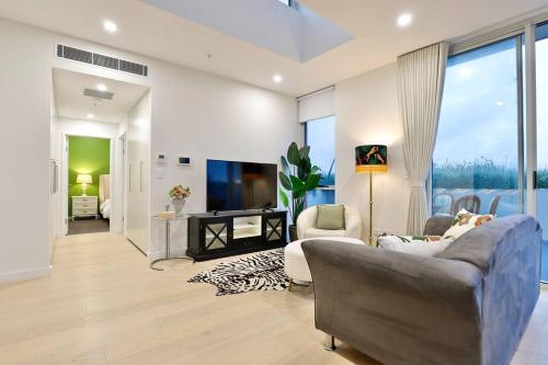 a living room with a couch and a tv at Lumière Sanctuary - Antique Elegance with Parking in Sydney