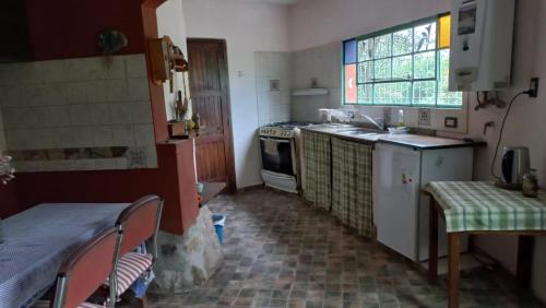 cocina pequeña con fregadero y fogones en Residencia zona sierras chicas (casa) El talar en Mendiolaza