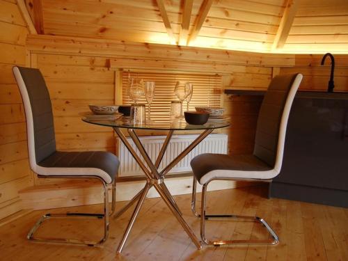 a table and two chairs in a cabin at Romantic Rural Retreats in Crewkerne