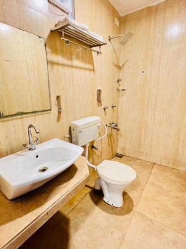 a bathroom with a white toilet and a sink at Abalone Resort in Arpora