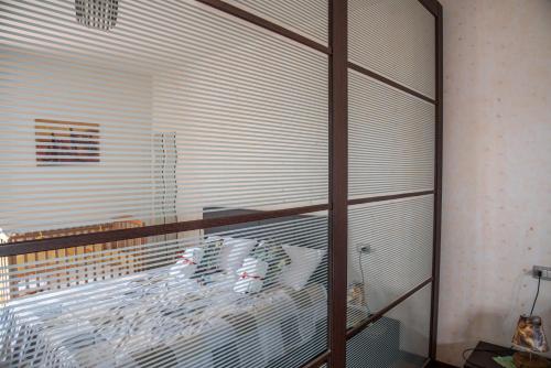 a room with a bed with a glass window at Via della musica in Vicchio
