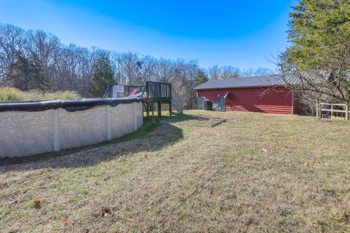 a yard with a fence and a red barn at Cozy Cottage with Pool Btwn Knoxville and Pigeon Forge in Strawberry Plains