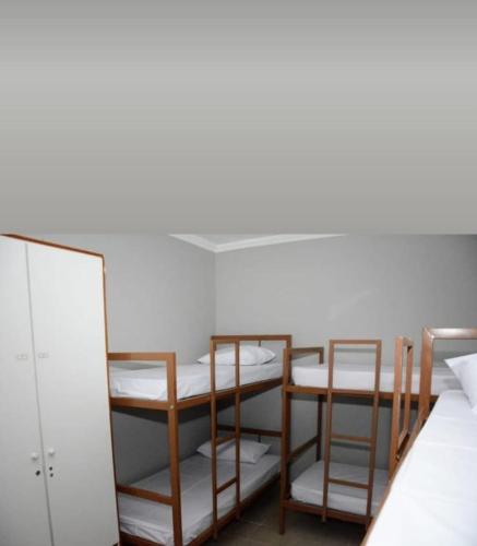 a room with three bunk beds and a mirror at Caucaia Cit in Caucaia