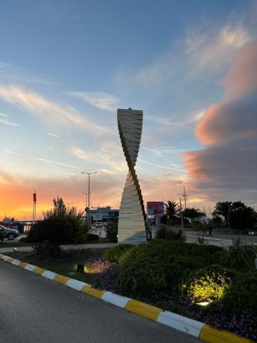 uma escultura ao lado de uma estrada ao pôr-do-sol em Urban Oasis em Šušanj