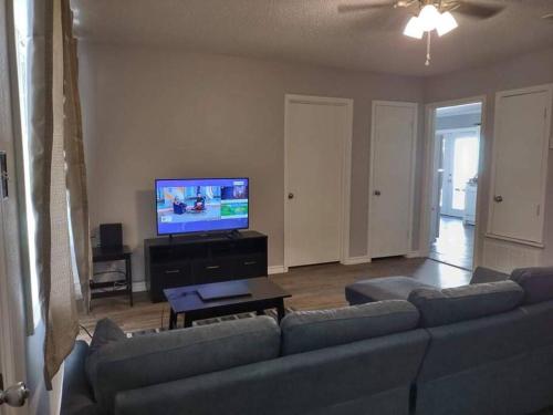 sala de estar con sofá y TV de pantalla plana en Lovely 4 BR Home Near Fort Johnson-14 Minute Drive en Leesville