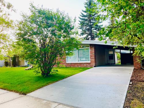 a brick house with a driveway in front of it at ! 5 Bed Beautiful Home with Fenced Yard & Hammock! WEM - Foosball Table - WiFi - Fireplace - Long Stay in Edmonton