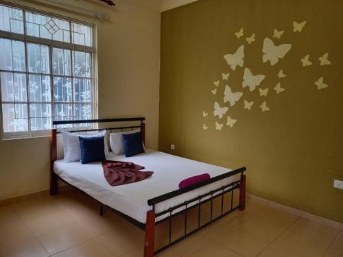 a bedroom with a bed with butterflies on the wall at Nature's Nest Kandy in Kandy