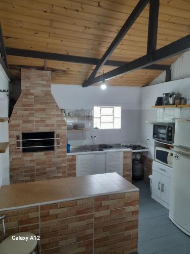 a kitchen with a brick oven in the middle at Casa de Praia da LOMBA in Florianópolis