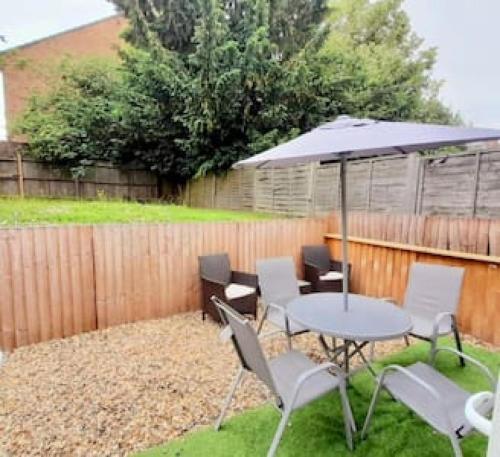 a patio with a table and chairs and an umbrella at Luxurious Ensuite in Edgware