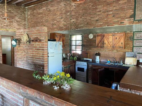 a kitchen with a white refrigerator and a brick wall at Casa Grande en Raco ideal familias in Raco