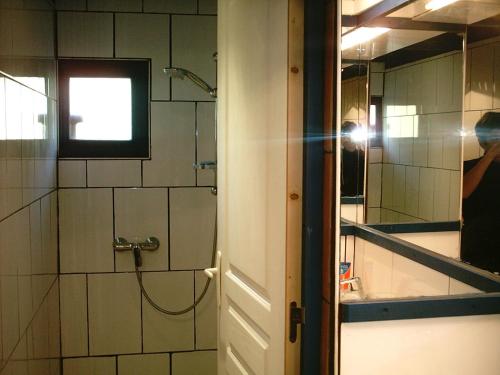 une personne prenant une photo d'une douche dans une salle de bains dans l'établissement La Coquille Napoléon, à Saint-Jean-Pied-de-Port