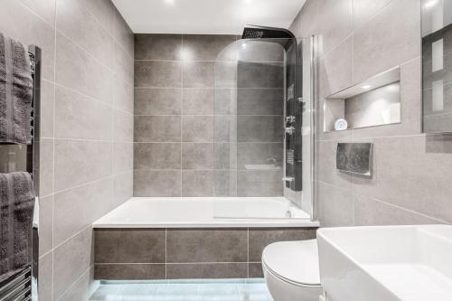 ein Badezimmer mit einer Badewanne, einem WC und einem Waschbecken in der Unterkunft Guest Homes - Maple Court in Ipswich