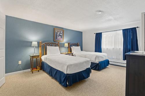 2 Betten in einem Zimmer mit blauen Wänden in der Unterkunft Overlook in Warrensburg