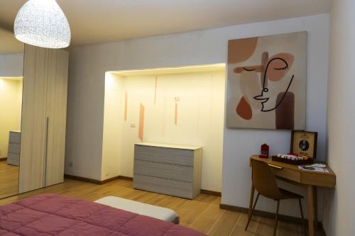 sypialnia z łóżkiem, biurkiem i obrazem w obiekcie Assisi Suite Relax, Bilocale nel centro storico w Asyżu