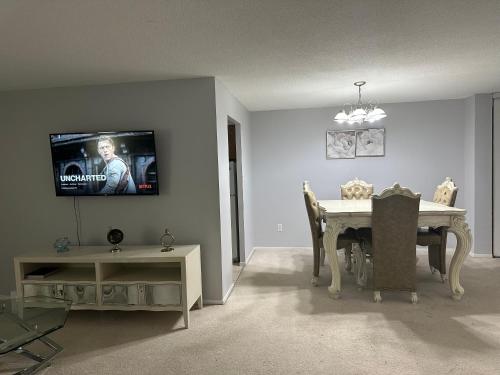 uma sala de estar com uma mesa e uma televisão na parede em Osaru Abel Omoruyi em Mississauga