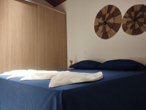 a bed with blue sheets and blue pillows on it at Apartamento Condomínio Villaggio di Mare - Barra Grande, Maraú - BA in Marau