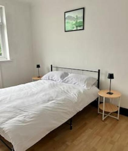 um quarto com uma cama branca e uma mesa lateral em Pair Paradise Haven - Double room em Londres