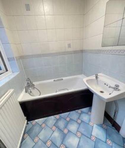 uma casa de banho com uma banheira branca e um lavatório. em Pair Paradise Haven - Double room em Londres