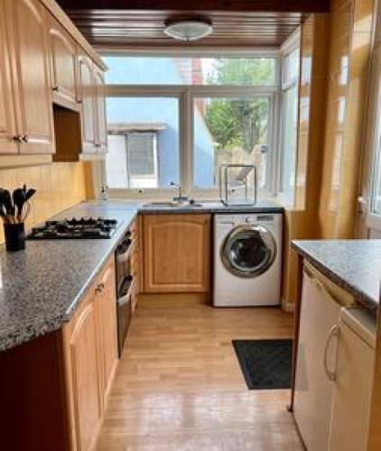 a kitchen with a washing machine and a window at Pair Paradise Haven - Double room in London