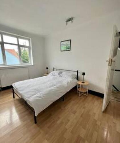 um quarto branco com uma cama e uma janela em Pair Paradise Haven - Double room em Londres
