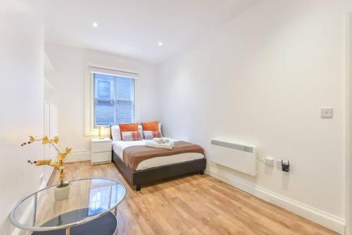 a bedroom with a bed and a glass table at 2 Bed Piccadilly Apartment- 1 in London