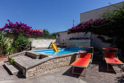 a swimming pool with two chairs and a slide at Villa Erika with private pool and garden - Happy Rentals in Lecce