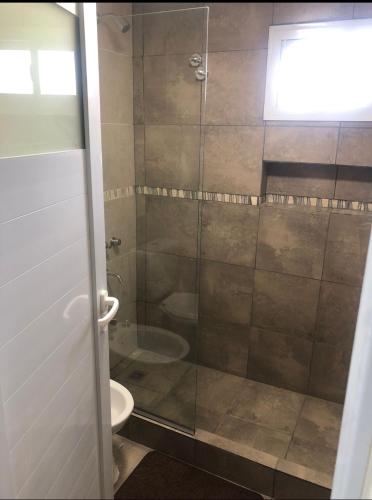 a bathroom with a glass shower with a toilet at Cuatro Elementos in Villa Parque Siquiman