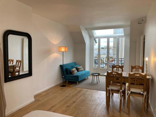 - un salon avec une table et un canapé bleu dans l'établissement Saint Sulpice Towers, à Paris
