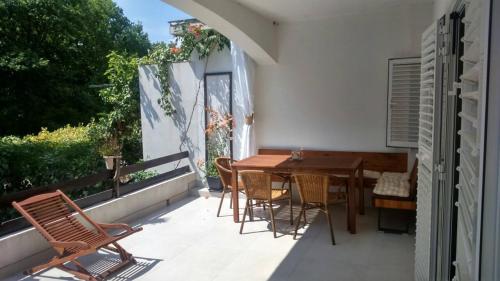 a patio with a wooden table and chairs on a balcony at Apartment Lena in Čižići