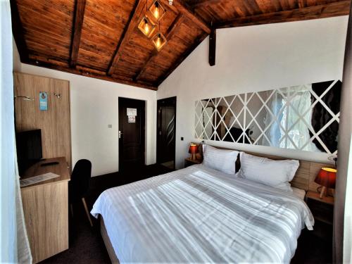 een slaapkamer met een groot bed en een houten plafond bij Casa Catalea in Sinaia