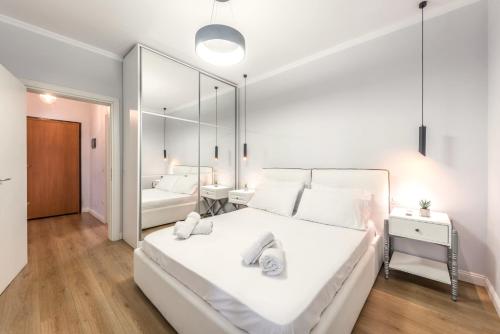 a bedroom with a large white bed and a mirror at Luxurios Modern Apartment Marina Bay in Durrës