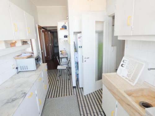 a kitchen with white cabinets and a checkered floor at Grandmotherhouse 2-7 Pax in Porto