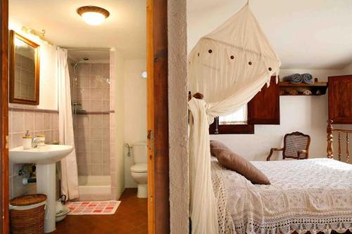 1 dormitorio con cama con dosel y baño en La Ginesta Rural, cerca de Sitges, en Canyelles