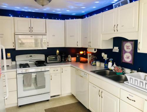 eine weiße Küche mit weißen Schränken und einer Spüle in der Unterkunft The Wellington Lake Cottage in Middlebury