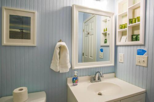 La salle de bains est pourvue d'un lavabo et d'un miroir. dans l'établissement Walking on Sunshine, à Isle of Palms