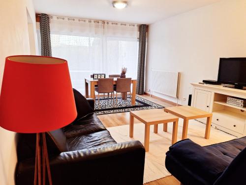 - un salon avec un canapé et une lampe rouge dans l'établissement 2 Bedroom Condomium with Terrace & Garden, à Saint-Germain-en-Laye