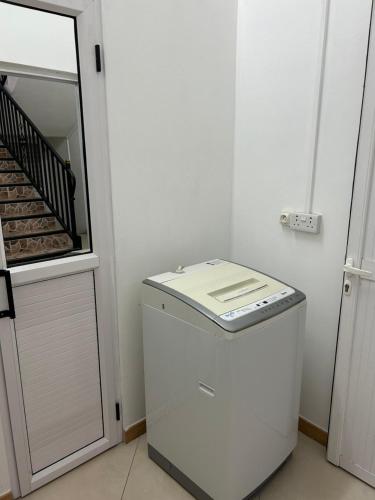 a white refrigerator in a room with a staircase at VMKY apartments in Triolet