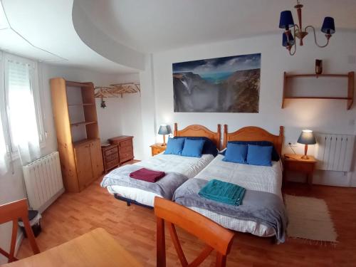 1 dormitorio con 1 cama grande con almohadas azules en MERINDADES AMAZUL MILANO Piso turístico Medina de Pomar, en Medina de Pomar
