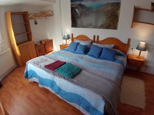 1 dormitorio con 1 cama grande con almohadas azules en MERINDADES AMAZUL MILANO Piso turístico Medina de Pomar en Medina de Pomar