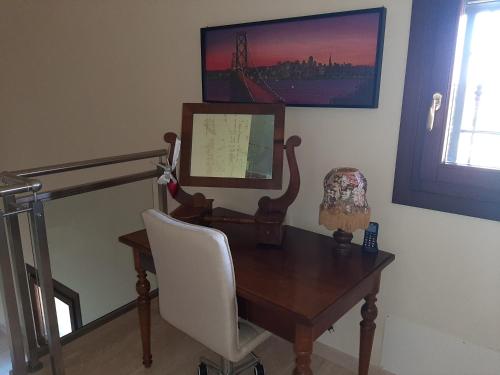 a desk with a chair and a picture on the wall at La Mimosa in Dozza