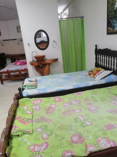 a bedroom with two beds and a green curtain at Casa campestre Rancho San Juan in El Pantano